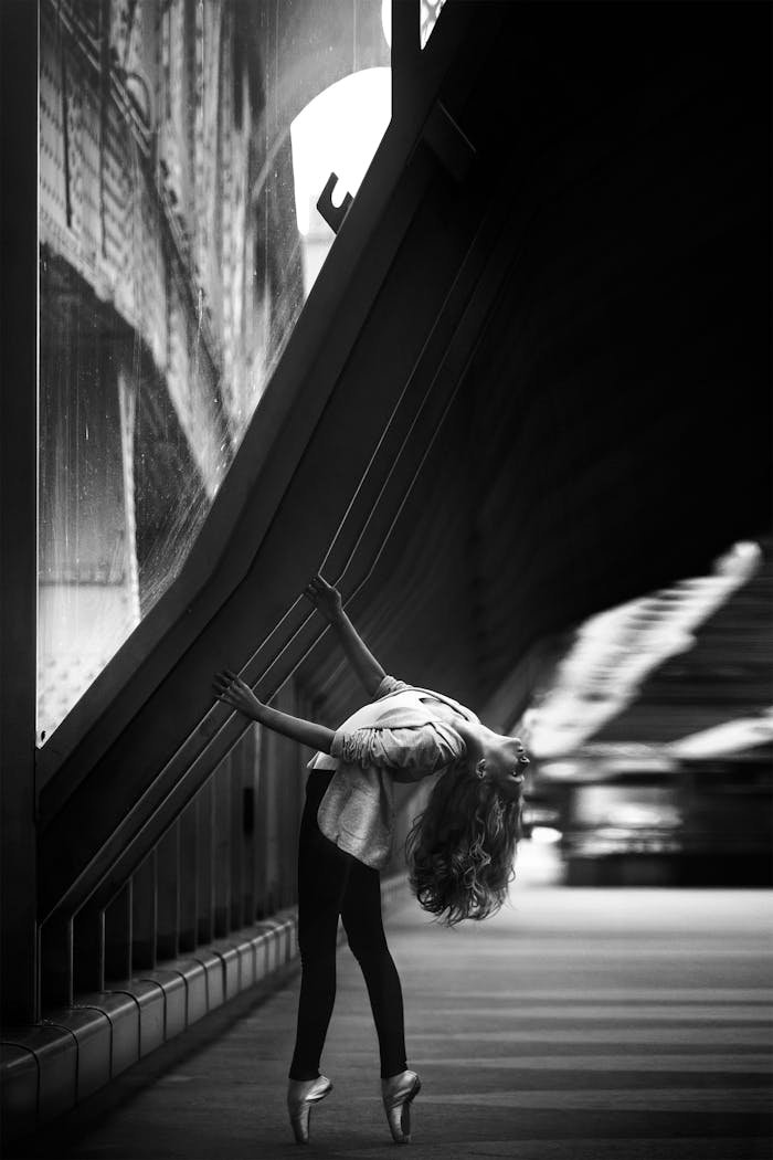 A talented ballerina in an urban setting, captured in a black and white aesthetic.